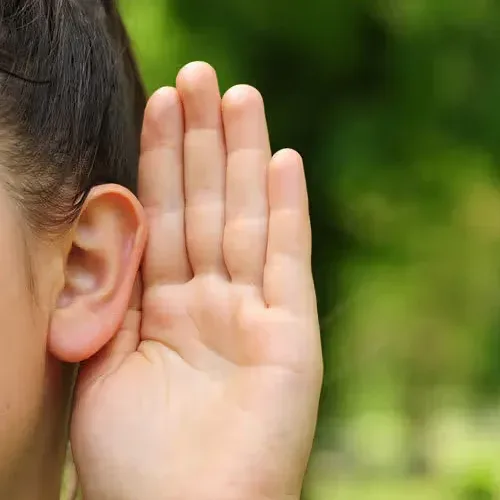 Hand cupped behind an ear to listen